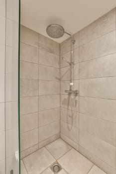 a shower with white tiles on the wall and green trim around the door, in a bathroom reurre