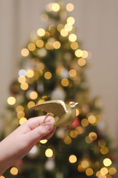 Decorating Christmas tree, holding Christmas toy in a hand. Holiday, Christmas and New Year family celebration concept. High quality photo