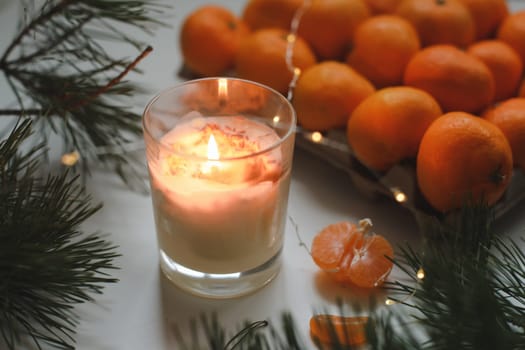 Candle, tangerines and pine. Christmas background with fir tree branches and tangerines merry christmas and happy new year. High quality photo