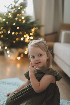 Little girl decorating christmas tree with toys and baubles. Cute kid preparing home for xmas celebration