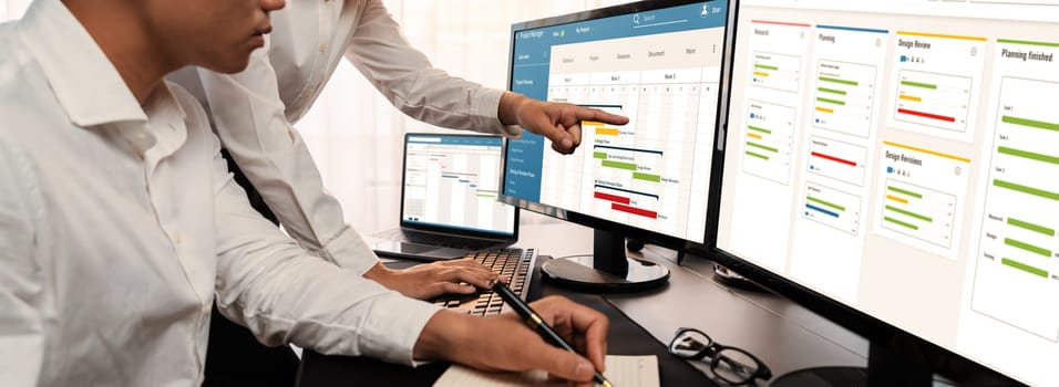 Project management team coordinating and update project planned schedule on computer using Gantt chart software in office. Business people planning time and deadline for company task. Trailblazing