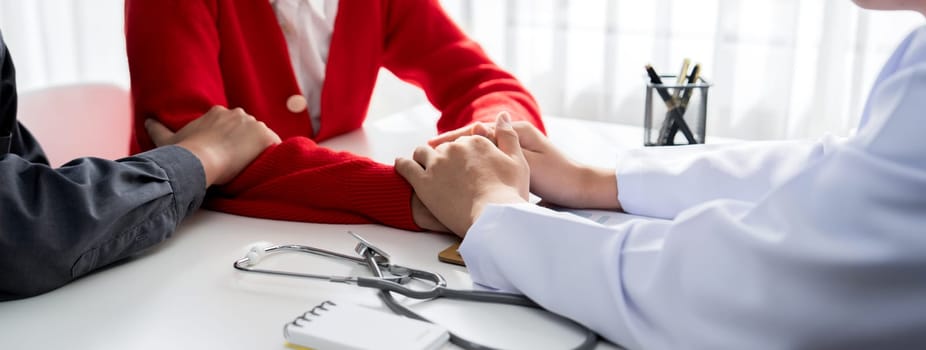 Couple attend fertility or medical consultation with gynecologist at hospital as family planning care for pregnancy while doctor and husband consoling young wife through appointment. Panorama Rigid