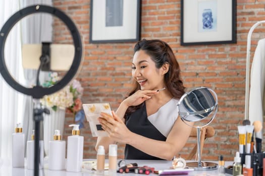 Woman influencer shoot live streaming vlog video review makeup uttermost social media or blog. Happy young girl with cosmetics studio lighting for marketing recording session broadcasting online.