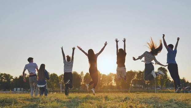 Merry friends bouncing around at sunset