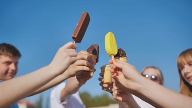 Friends link together colorful popsicles on a stick