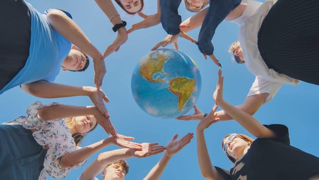 Young boys surround the globe of the world with their palms. The concept of preserving world peace
