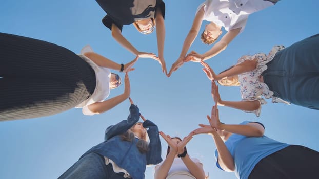 School children make a heart shape from their hands