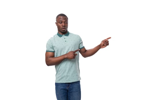 young slender American man dressed in a T-shirt and jeans with surprise shows his hand to the side.