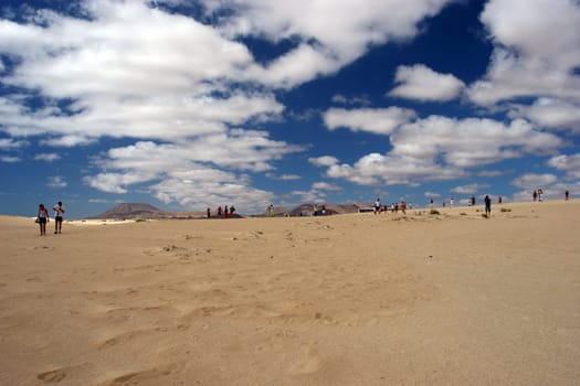 Tourists on the shifting dune in the north of Fuerteventura.