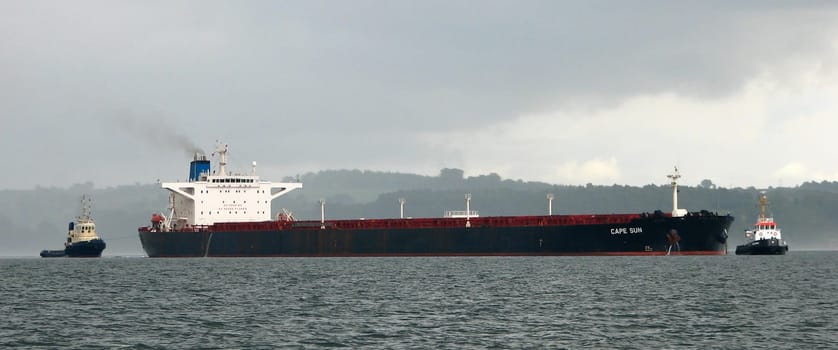 One tug pulls at the front and the second at the rear is used for steering.