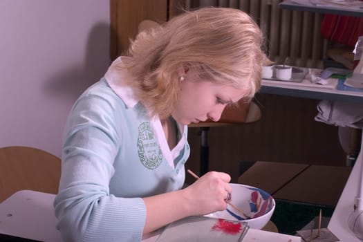 College-teacher painting a porcelain bowl