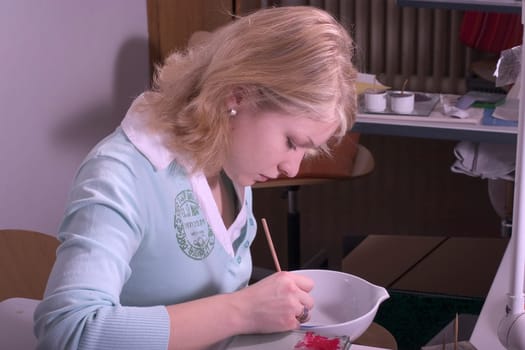 College-teacher painting a porcelain bowl
