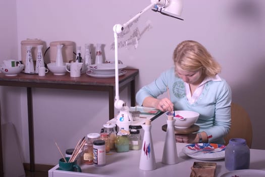 College-teacher painting a porcelain bowl