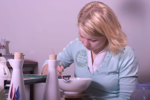 College-teacher painting a porcelain bowl