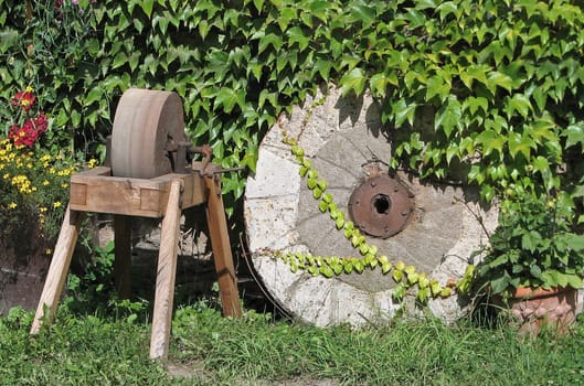 Grinding machine next to old millstone