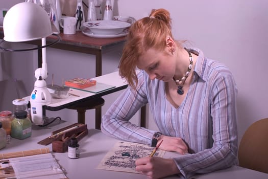 College-teacher painting and writing a Kallligaph work.