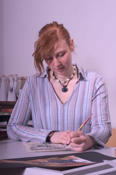 High school student painting and writing a kalligaphic work.