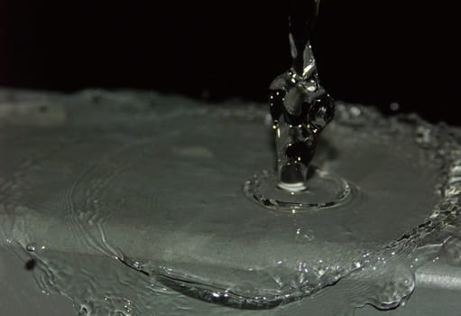 The image shows a human torso formed from water. A water sculpture