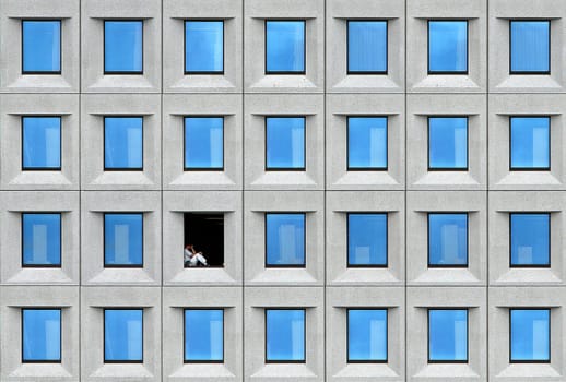 Lunch break with a difference. Captured from the ship at the port entrance of Copenhagen. The man was sitting there,not a photomontage. The world's largest container line,the Danish shipping company Maersk Sealand,here the office building in Copenhagen