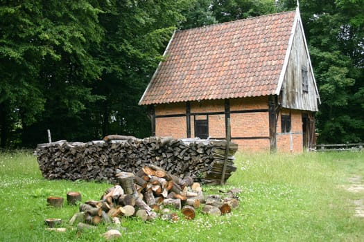 Half-timbered shed with stack of firewood