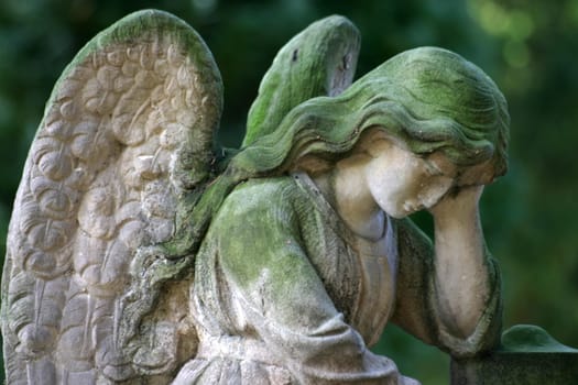 Green mossy angel figure on a grave