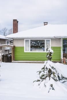 Entrance of residential house with front yard in snow. Family house on winter cloudy day