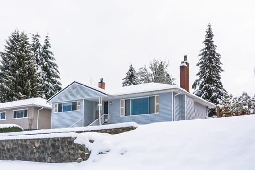Single family residential house with front yard in snow. Average North American house on winter cloudy day