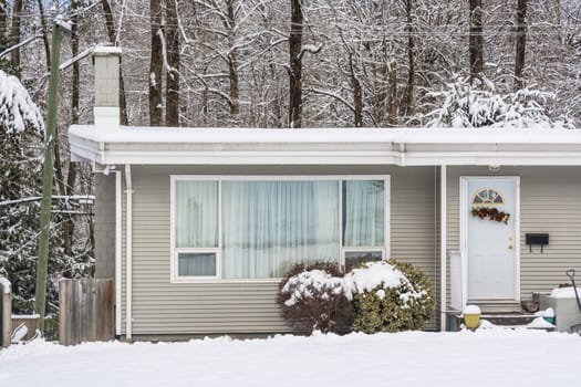 Entrance of residential house with front yard in snow. Family house on winter cloudy day