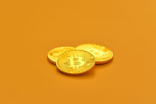 Three yellow bitcoin beans laying on flat surface