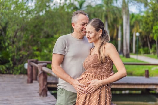 A happy, mature couple over 40, enjoying a leisurely walk in a park, their joy evident as they embrace the journey of pregnancy later in life.