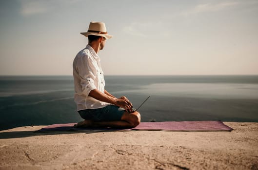 freelancer businessman working remotely on laptop at the beach near the sea