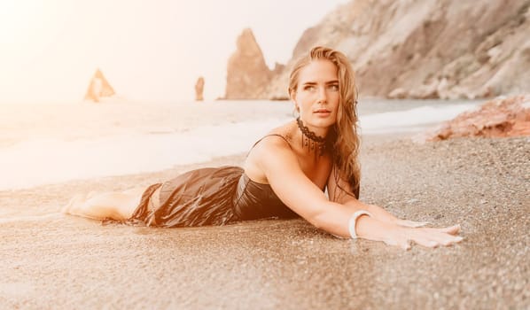 Woman travel sea. Young Happy woman in a long red dress posing on a beach near the sea on background of volcanic rocks, like in Iceland, sharing travel adventure journey