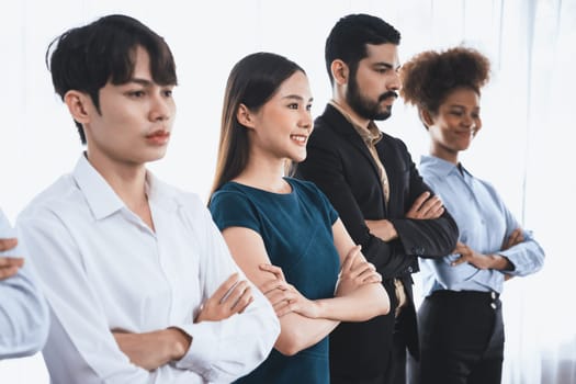 Diverse group of professional business people stand in line with cross arm gesture in modern corporate office. Happy and smiling multiracial office worker team bond and succeed together. Concord