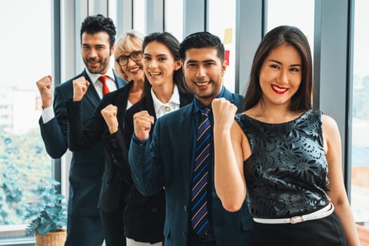 Successful business people standing together showing strong relationship of worker community. A team of businessman and businesswoman expressing a strong group teamwork at the modern office. Jivy