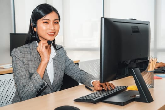 Business people wearing headset working in office to support remote customer or colleague. Call center, telemarketing, customer support agent provide service on telephone video conference call. Jivy