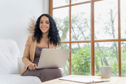 African-American woman using laptop computer for crucial work on internet. Secretary or online content writing working at home.