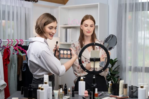 Woman influencer shoot live streaming vlog video review makeup utmost social media or blog. Happy young girl with cosmetics studio lighting for marketing recording session broadcasting online.