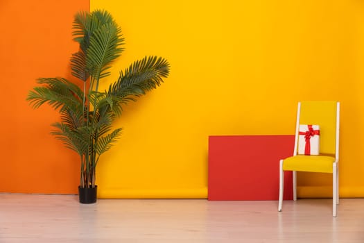 chair with gift in interior on yellow background