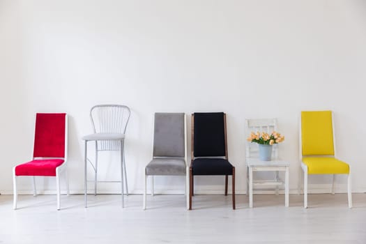 Lots of chairs in the interior of a white room