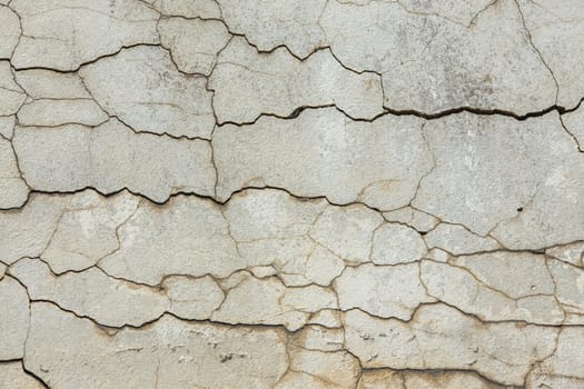 deep horizontal cracks on old wall plaster - full-frame texture and background.