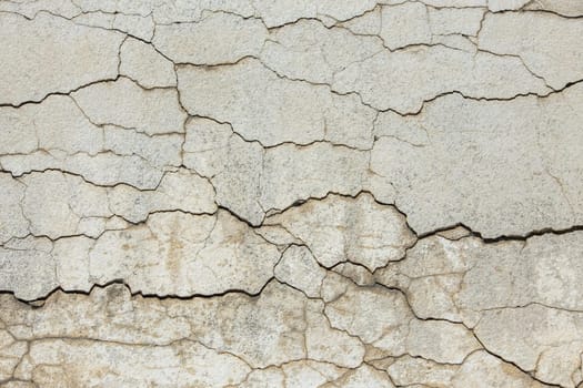 deep horizontal cracks on old wall plaster - full-frame texture and background.