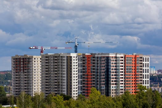 New cheap high-rise apartment building block under construction in Russia. Distant telephoto shot.