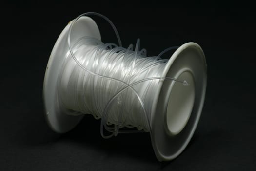 Clear thread on white plastic roll