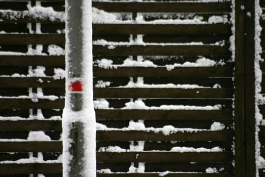 Snow-covered fence and lamppost