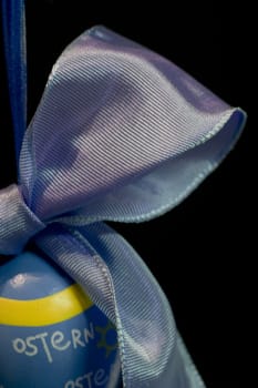 Easter egg with bow,cut on the left,against a black background