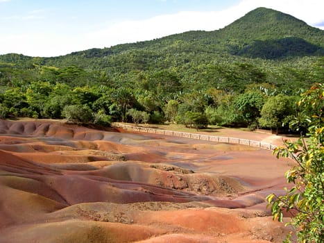 On the island of Mauritius,near the town of Chamarel,there is a place where the bare earth is revealed,there is no vegetation and the earth shines strangely in different colors. The earth is of volcanic origin,and the color results