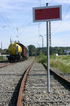 Railway line with wagons and barrier sign