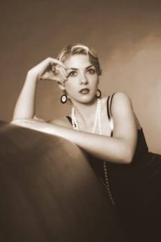Portrait photo of a woman dressed in the style of the 20s,sitting on a leather sofa