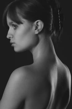 A woman,with her back turned to the camera,looks away longingly