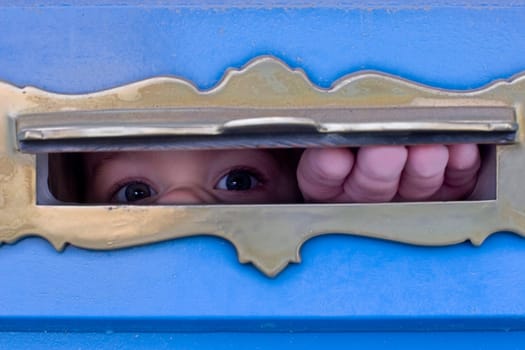Child looking through letter slot